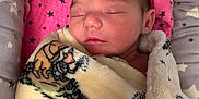 Nova is registered to the contest to win money with this photo: newborn, baby, sleeping, blanket, cozy, patterned_blanket, pink, gray, stars, soft, face, peaceful, wrapped, infant, cute, child, resting, portrait, indoors, closeup