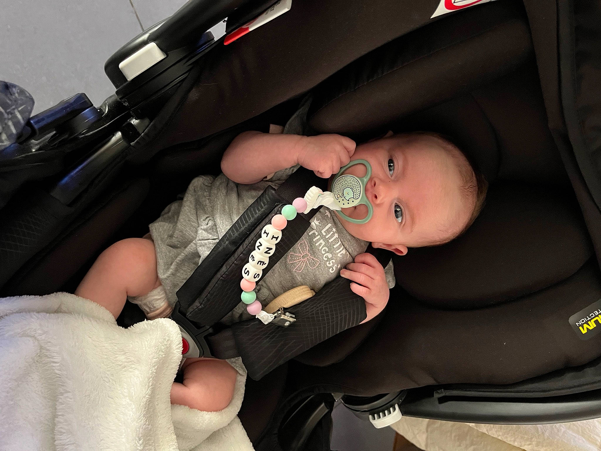 Inès a rejoint le concours — aidez-le/la à gagner de superbes lots ! auto_part, automotive_design, baby, baby_carriage, baby_in_car_seat, baby_products, baby_toddler_clothing, bag, car_seat, child, comfort, finger, hand, lap, nail, person, seat_belt, thigh, thumb, toddler