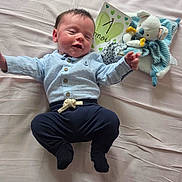 Gabin a rejoint le concours — aidez-le/la à gagner de superbes lots ! baby, infant, bed, plush_toy, card, blue_shirt, navy_pants, sleepy, lying_down, cute, soft_bed, celebration, one_month, child, newborn, smiling, person, indoors, fabric, cozy