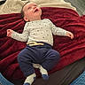 Gabin a rejoint le concours — aidez-le/la à gagner de superbes lots ! baby, infant, smiling, lying_down, blanket, red_blanket, beige_blanket, onesie, star_pattern, navy_pants, socks, happy, indoors, floor, jeans, person, child, cute, cozy, portrait