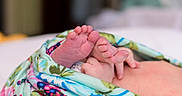 Octavia is registered to the contest to win money with this photo: baby, feet, hand, blanket, floral_pattern, newborn, skin, infant, closeup, cozy, soft, wrapped, colorful, indoors, cute, small, delicate, resting, peaceful, toddler