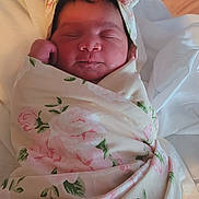 Emilianys Amirah is registered to the contest to win money with this photo: newborn, baby, sleeping, wrapped, blanket, floral_pattern, headband, infant, peaceful, soft, cute, portrait, indoors, resting, child, person, skin, face, cozy, warm