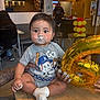 baby, child, birthday, cake, frosting, face_paint, onesie, balloon, number_six, table, party, celebration, indoor, people, chair, tattooed_arm, clothing, footwear, food, smudged
