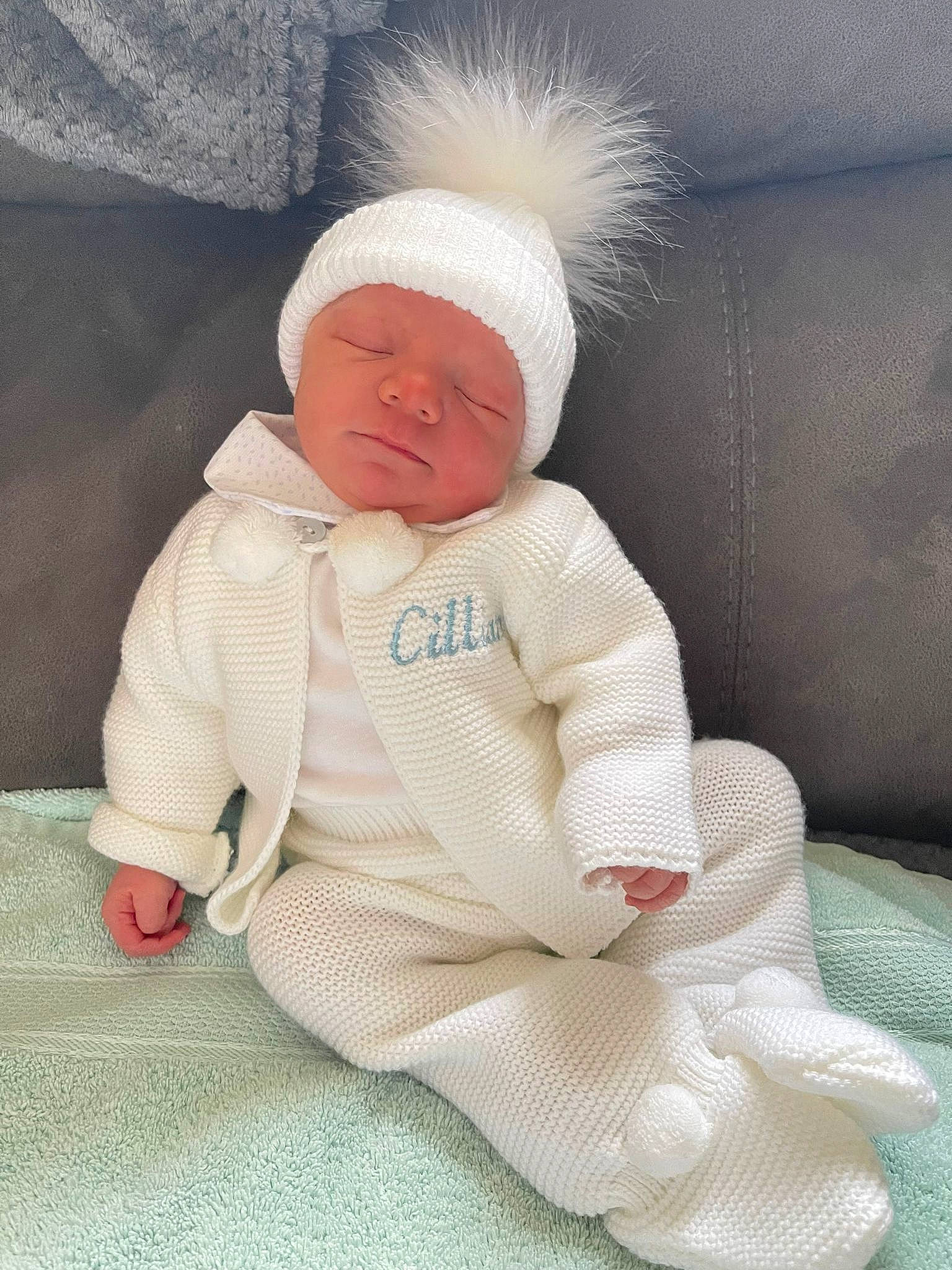 Cillian is registered to the contest to win money with this photo: baby, baby_products, baby_sleeping, baby_toddler_clothing, beanie, cap, carmine, child, comfort, fur, hat, head, knit_cap, lap, linens, outerwear, person, sitting, skin, toddler