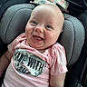 baby, smiling, infant, car_seat, pink_shirt, camo_pattern, heart_shape, happy, child, portrait, clothing, cute, closeup, seat, head_support, person, indoor, bright, expression, comfort