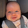 baby, infant, smiling, face, car_seat, seatbelt, clothing, pink, child, cute, happy, portrait, closeup, indoor, person, soft_toy, head, skin, eyes, newborn