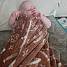 baby, blanket, brown, cushion, face, fleece, furniture, home, infant, indoors, lying_down, person, plush, portrait, resting, snug, soft, toddler, young_child, zipped
