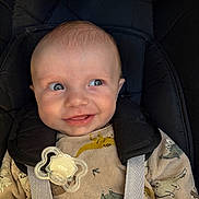 Thélio a rejoint le concours — aidez-le/la à gagner de superbes lots ! baby, infant, car_seat, pacifier, dinosaur_pattern, smile, blue_eyes, clothing, straps, cute, face, child, indoors, expression, head, person, seat, happy, young, portrait