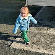 Isabel-Rae is registered to the contest to win money with this photo: casual_clothing, child, concrete, curly_hair, cute, daytime, denim_jacket, fashion, green_pants, outdoor, pavement, pose, shadow, sidewalk, small_person, street, sunlight, toddler, walking, young_child