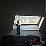 cat, window, couch, indoor, curious, stretching, skylight, furniture, clothing, dim_light, room, pet, animal, looking_out, home, cozy, table, chair, living_room, curiosity