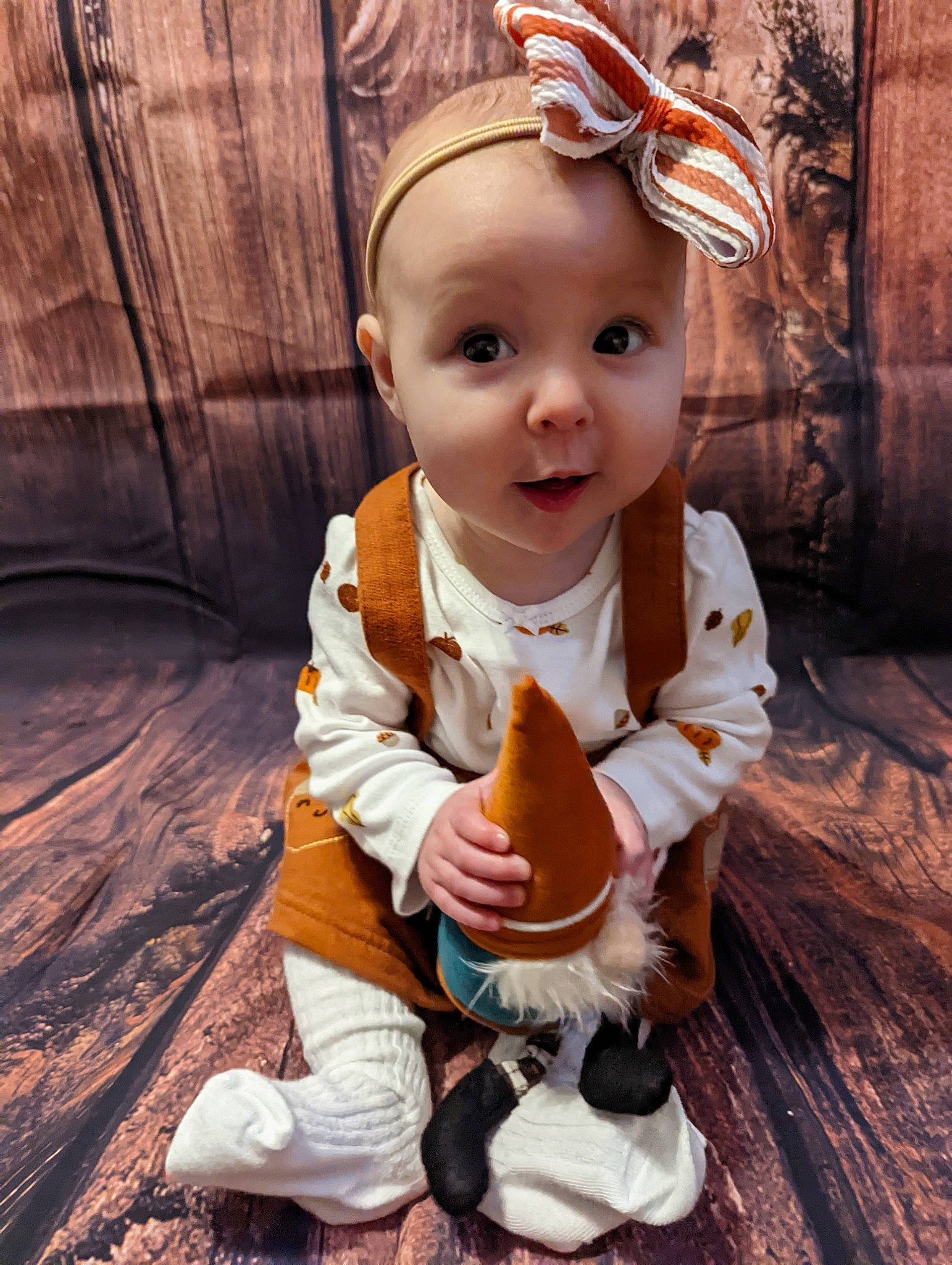 Hannah is registered to the contest to win money with this photo: arm, baby, baby_toddler_clothing, cheek, child, eye, fawn, flooring, fun, grass, hand, happy, head, headband, human_body, person, sitting, skin, smile, surprise