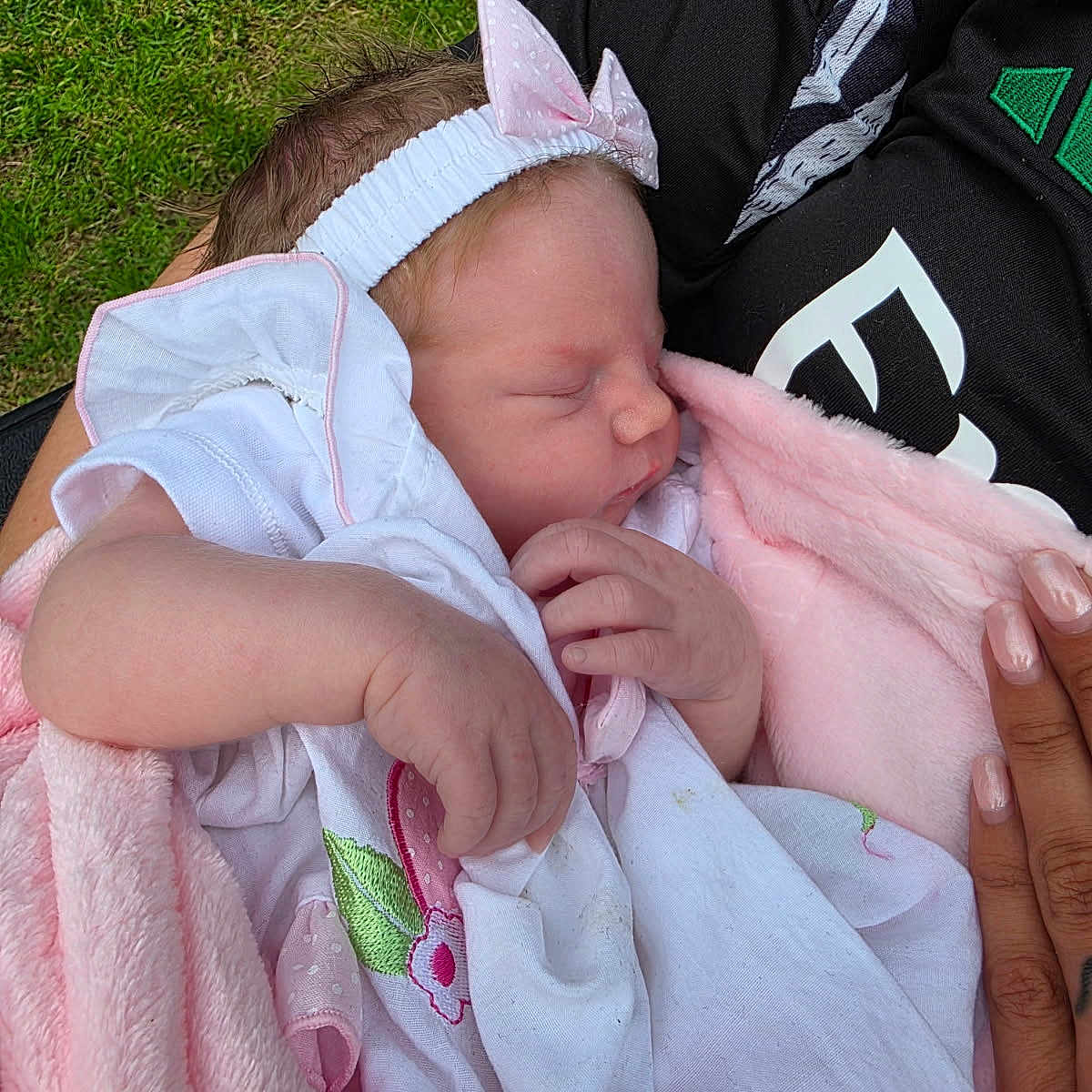 Patciè-Eileen is registered to the contest to win money with this photo: baby, blanket, bow, child, closeup, gentle, grass, hands, headband, holding, infant, manicured_nails, newborn, outdoor, peaceful, person, pink, sleeping, soft_texture, white_clothing