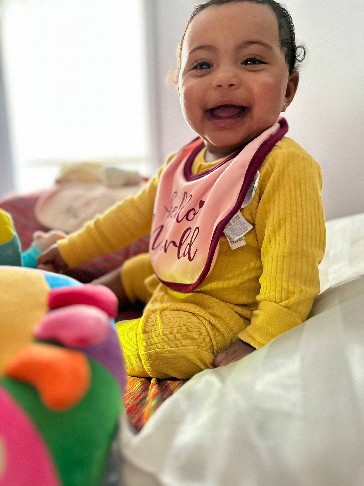 Jaylani is registered to the contest to win money with this photo: baby, baby_toddler_clothing, child, comfort, dress, event, facial_expression, finger, fun, gesture, happy, joy, person, pink, room, sitting, skin, sleeve, smile, thumb