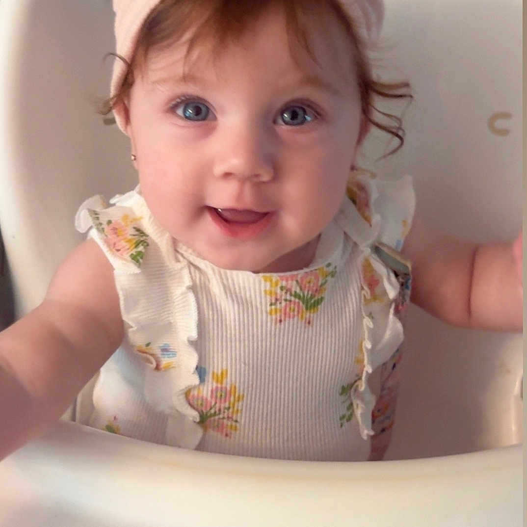 Jazalina is registered to the contest to win money with this photo: baby, blue_eyes, bow, child, closeup, cute, dress, floral, hair, happy, headband, high_chair, indoor, infant, person, pink, portrait, ruffles, skin, smile