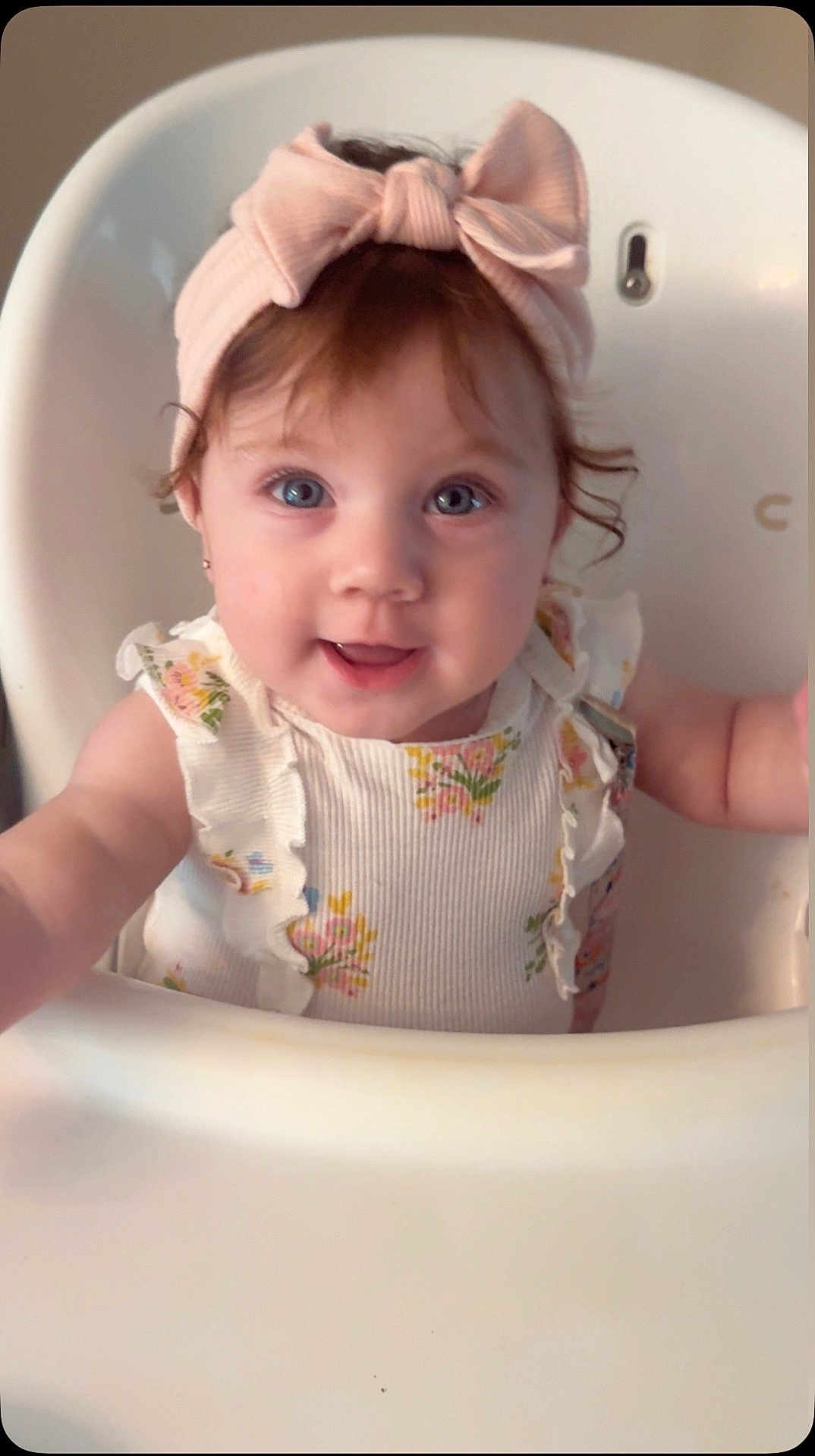 Jazalina is registered to the contest to win money with this photo: baby, child, high_chair, headband, pink, bow, smile, blue_eyes, floral, dress, ruffles, cute, portrait, indoor, infant, person, happy, closeup, skin, hair