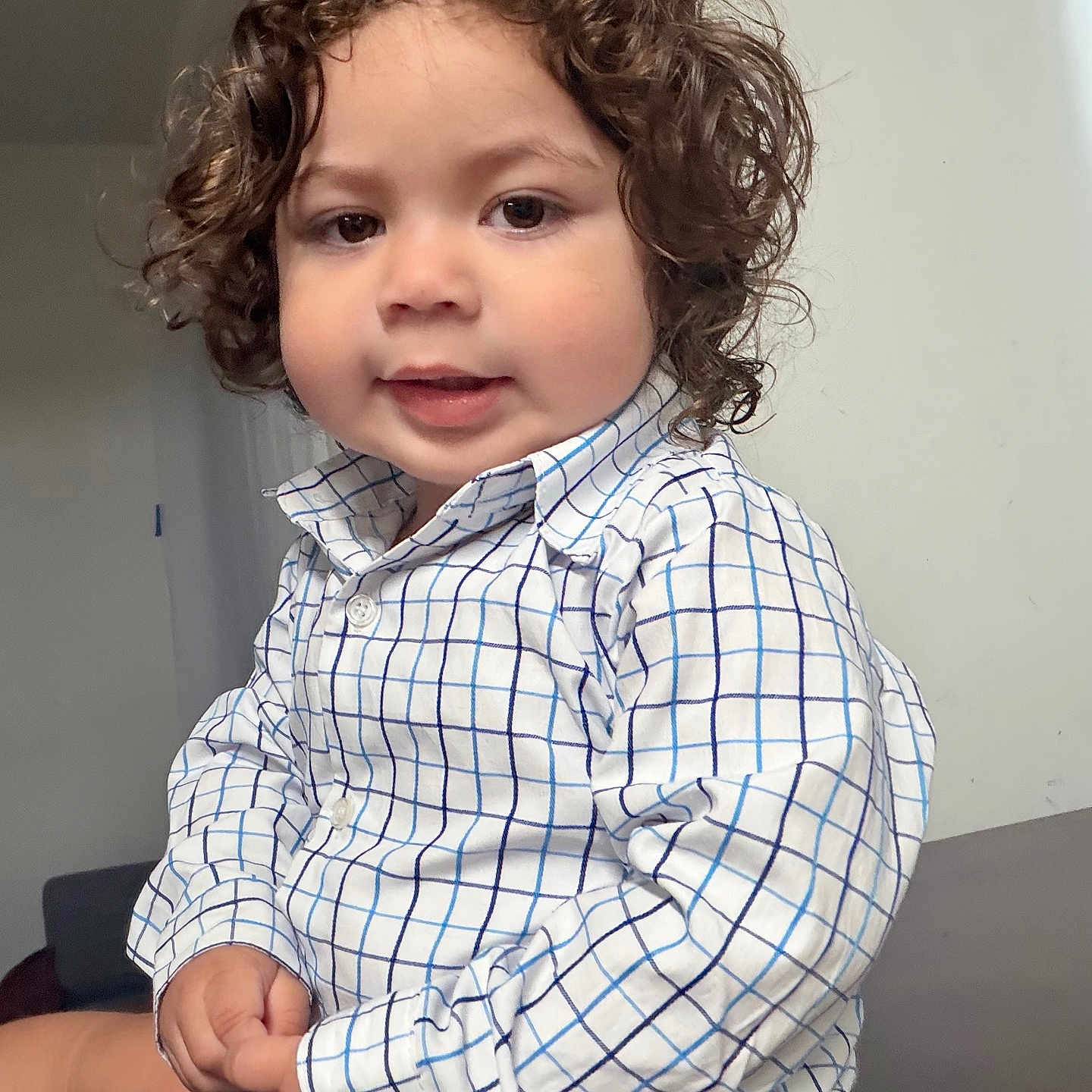 Angel Cordova joined the competition — help win amazing prizes! child, toddler, curly_hair, checkered_shirt, indoor, person, smile, cute, portrait, young_child, sitting, hands, face, eyebrows, skin, clothing, background, casual, expression, holding