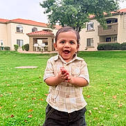 Ryaan is registered to the contest to win money with this photo: toddler, child, grass, outdoor, clothing, happy, barefoot, greenery, tree, building, lawn, smile, person, casual, daylight, nature, yard, playful, young_child, park