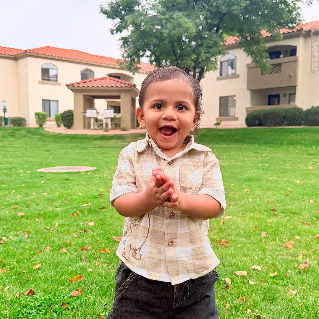 Ryaan is registered to the contest to win money with this photo: toddler, child, grass, outdoor, clothing, happy, barefoot, greenery, tree, building, lawn, smile, person, casual, daylight, nature, yard, playful, young_child, park