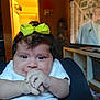 Luna is registered to the contest to win money with this photo: baby, bow, white_clothing, hands, indoor, television, furniture, person, child, face, hair, curly_hair, living_room, expression, closeup, sitting, candid, cute, smile, bright_color