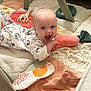 baby, infant, onesie, playmat, toy, plush, giraffe_toy, smiling, happy, crawling, indoor, child, cute, soft_toys, floor, blanket, face, person, playtime, home