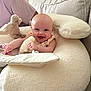 Fiadh joined the competition — help win amazing prizes! baby, smiling, couch, cushion, plush_toy, person, indoor, soft_toy, happy, head, face, child, furniture, relaxing, comfort, seated, clothing, light, home, infant