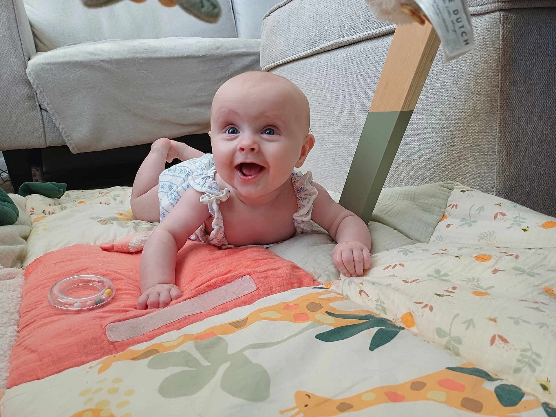 Fiadh is registered to the contest to win money with this photo: baby, smiling, play_mat, cushion, indoor, furniture, happy, infant, child, colorful, clothing, person, head, face, toddler, soft, floor, toy, blanket, home