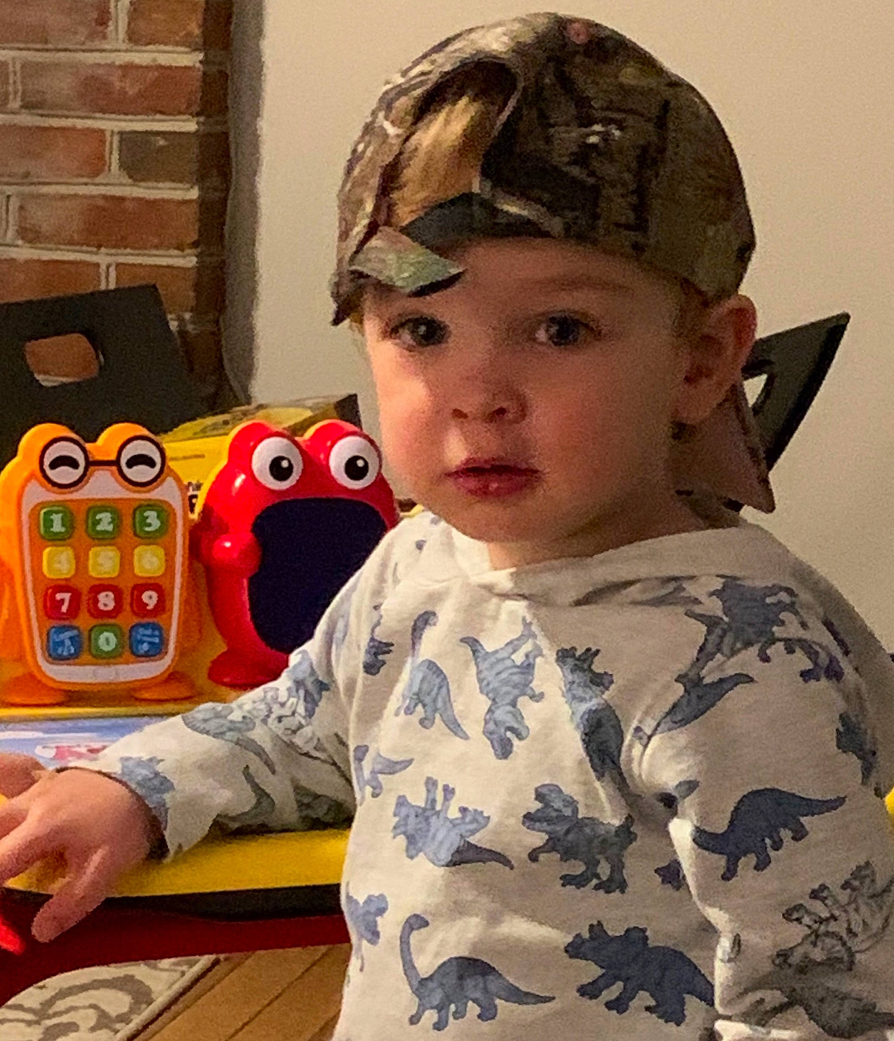 Tristan is registered to the contest to win money with this photo: cap, child, ear, electronic_device, games, headgear, headwear, person, play, toddler