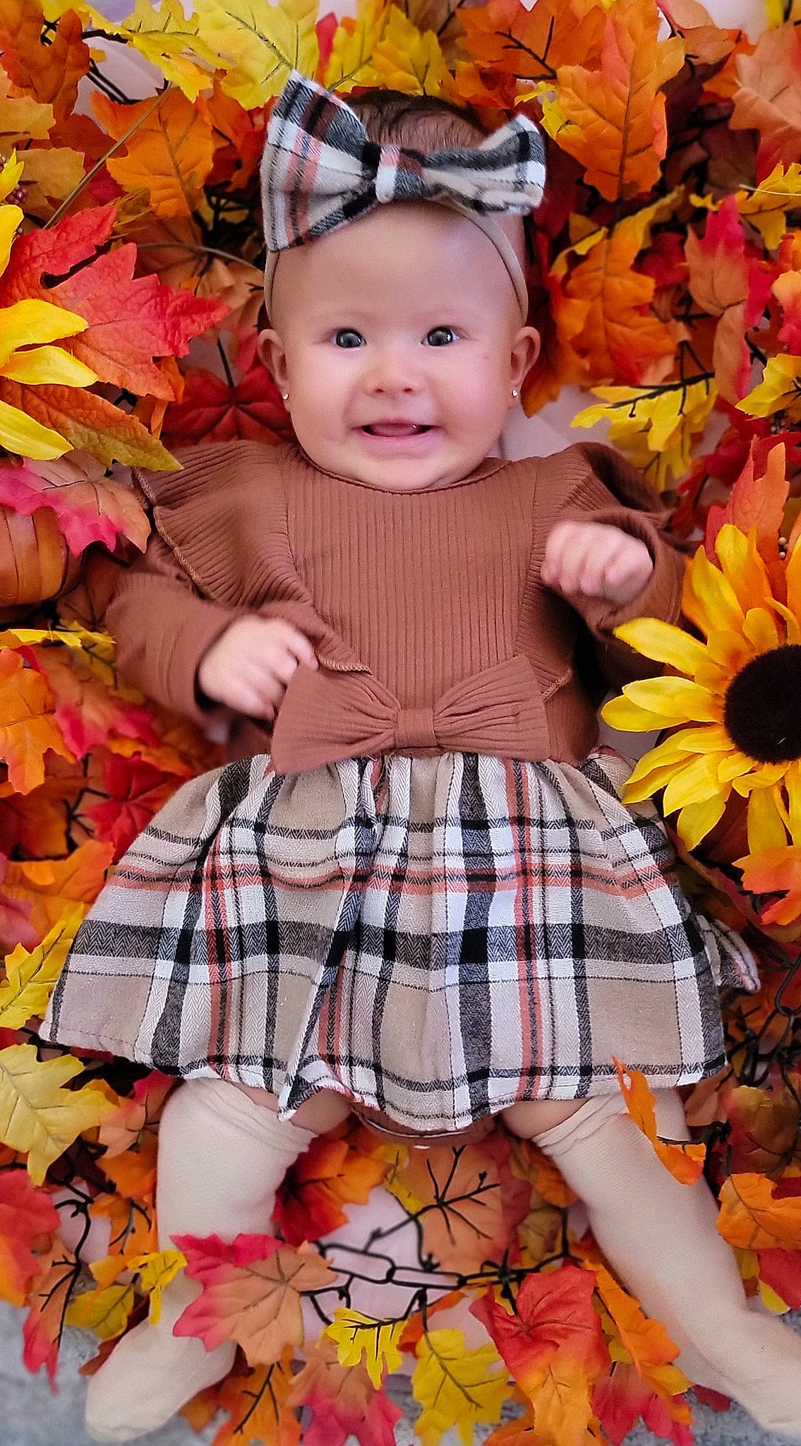 Valentina is registered to the contest to win money with this photo: baby_toddler_clothing, ball, beauty, child, dress, facial_expression, fawn, grass, happy, joy, leaf, orange, people_in_nature, person, pink, plaid, plant, smile, tartan, toddler