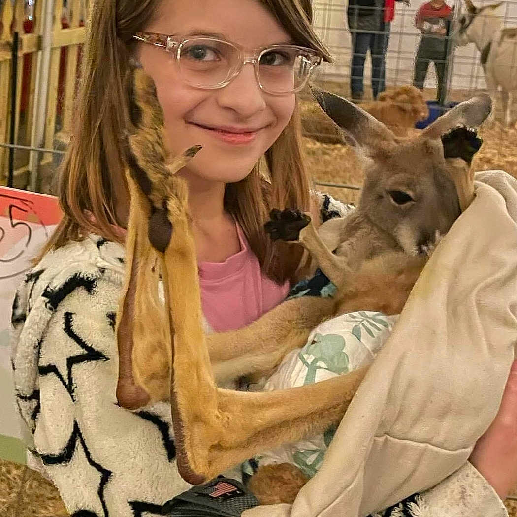 Lillian joined the competition — help win amazing prizes! accessories, adult, animal, blanket, female, food, glasses, hair, kangaroo, lady, meat, mutton, person, photobombing, woman, zoo