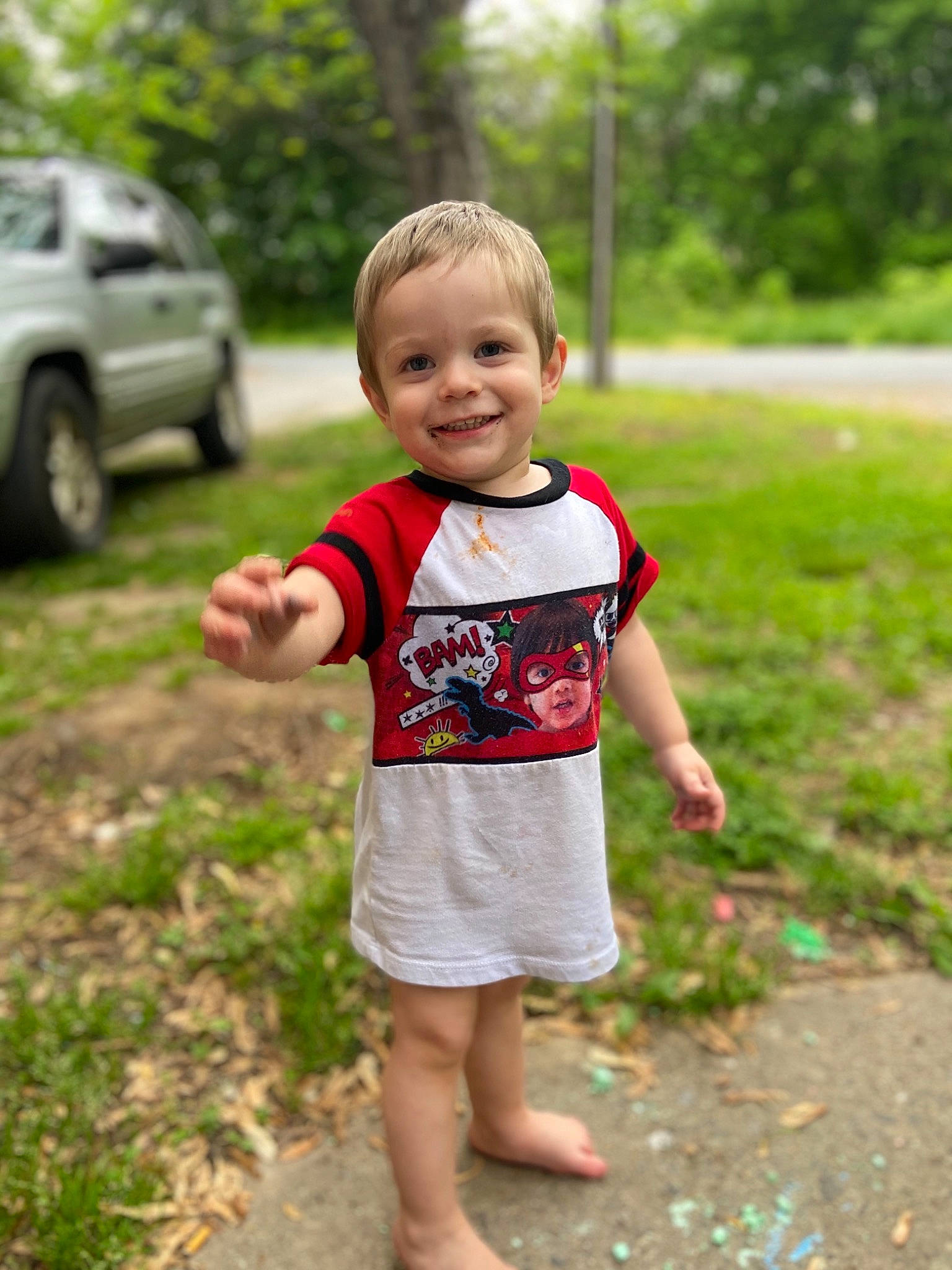 Ethan is registered to the contest to win money with this photo: child, facial_expression, finger, fun, grass, green, hand, head, joy, leaf, people, person, photography, plant, play, smile, standing, summer, toddler, tree