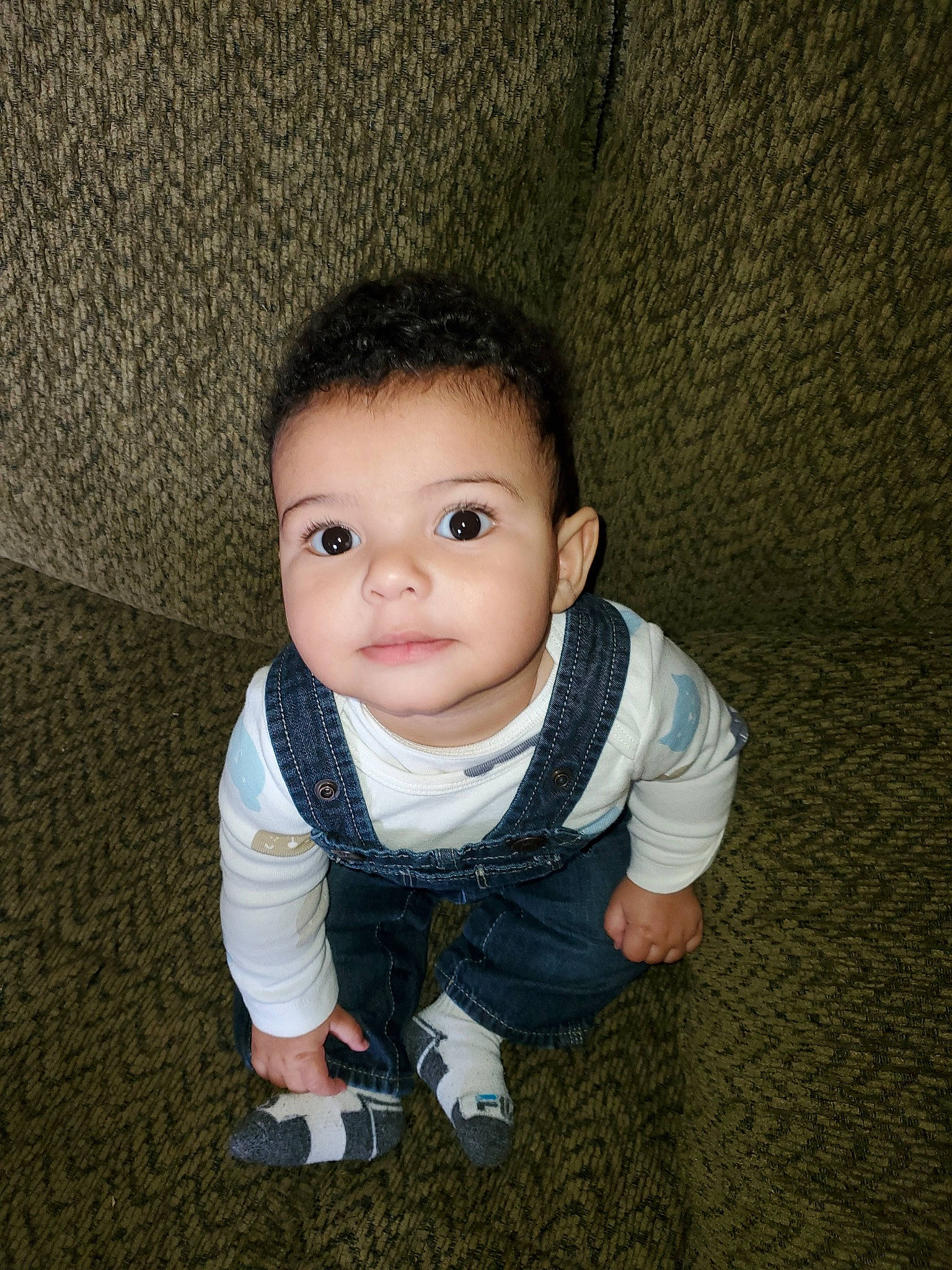 Mack is registered to the contest to win money with this photo: baby, cheek, child, chin, eye, fun, nose, outerwear, person, photography, sitting, skin, smile, snapshot, standing, toddler, wood