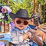 baby, child, cowboy_hat, sunglasses, plaid_shirt, jeans, hand, outdoor, forest, flowers, people, table, food, sunny_day, casual_clothing, portrait, fashion, cute, nature, event