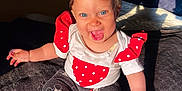 Leyna participe au concours pour gagner de l'argent avec cette photo : baby, child, smiling, curly_hair, blue_eyes, sitting, clothing, red, white, polka_dot, pants, mickey_mouse, foot, hand, blanket, sunlight, indoor, happy, cute, portrait