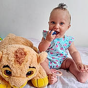 Leyna a rejoint le concours — aidez-le/la à gagner de superbes lots ! baby, child, infant, plush_toy, stuffed_animal, lion, toy, bed, white_bedspread, smile, blue_eyes, topknot, cute, sitting, happy, indoor, light_background, person, chewing_toy, playful