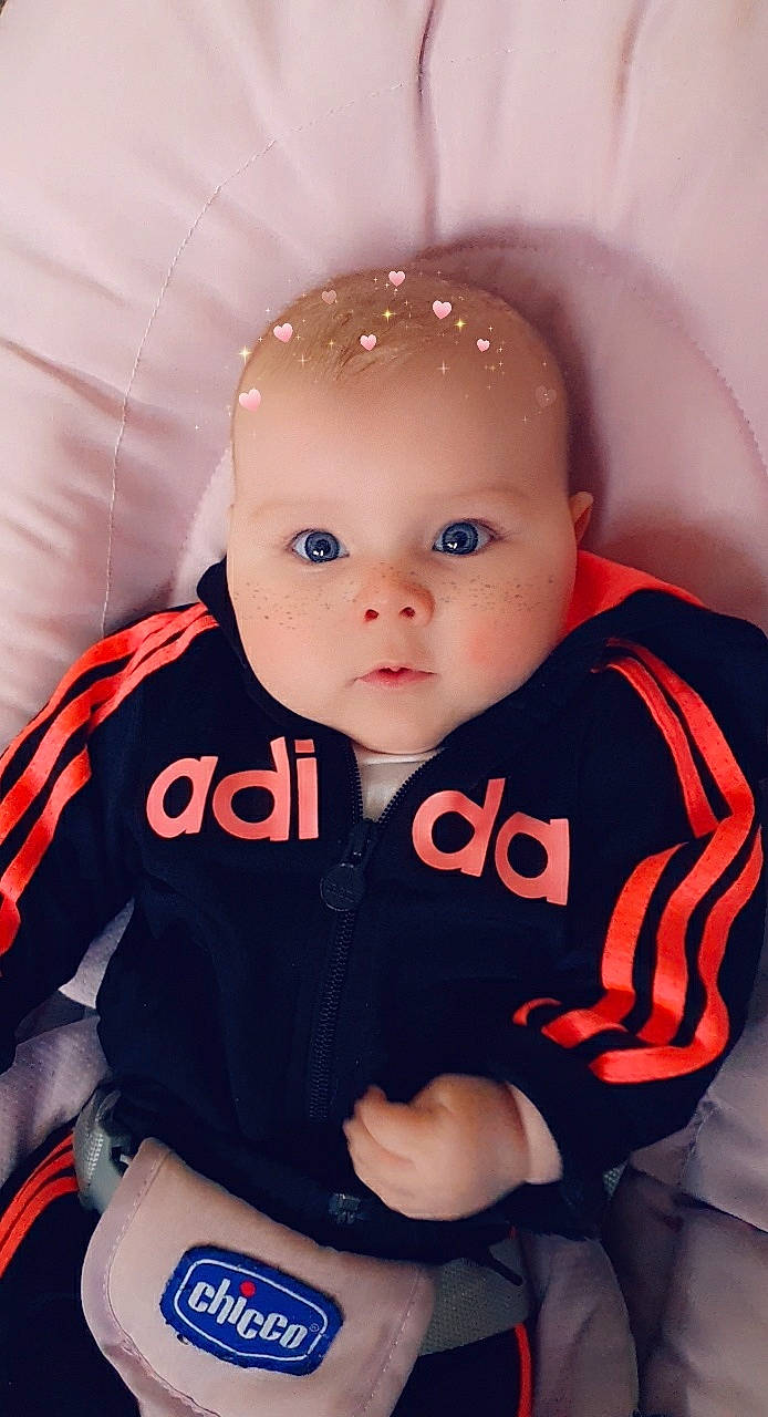 Lizzie a rejoint le concours — aidez-le/la à gagner de superbes lots ! baby, baby_products, baby_toddler_clothing, cheek, child, comfort, hood, orange, person, sitting, sleeve, sweatshirt, toddler