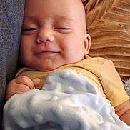 Mathéo participe au concours pour gagner de l'argent avec cette photo : baby, blanket, child, closeup, comfort, couch, cushion, face, furniture, hand, indoors, infant, person, portrait, relaxation, resting, sleepy, smile, soft_texture, yellow_clothing