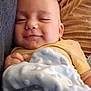 baby, blanket, child, closeup, comfort, couch, cushion, face, furniture, hand, indoors, infant, person, portrait, relaxation, resting, sleepy, smile, soft_texture, yellow_clothing