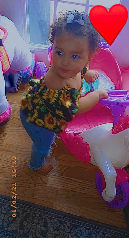 Kamari is registered to the contest to win money with this photo: baby_toddler_clothing, child, event, eye, face, flooring, fun, hair, happy, hardwood, head, leg, leisure, magenta, person, pink, play, purple, sitting, toddler