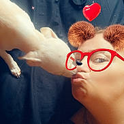 Lola participe au concours pour gagner de l'argent avec cette photo : affection, bear_ears, black_background, casual, closeup, cute, dog, face_filter, glasses, heart, indoor, interaction, lying_down, necklace, pet, portrait, skin, sparkles, white_dog, woman