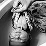 Lily participe au concours pour gagner de l'argent avec cette photo : baby, infant, hand, cloth, patterned_cloth, bathtub, water, sleeping, peaceful, skin, wrapping, holding, closeup, monochrome, black_and_white, newborn, portrait, soft, quiet, resting
