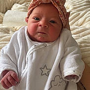 Lily a rejoint le concours — aidez-le/la à gagner de superbes lots ! baby, infant, onesie, headwrap, blanket, hand, face, portrait, cozy, cute, newborn, soft, sleepwear, star, cloud, fabric, resting, indoors, person, clothing