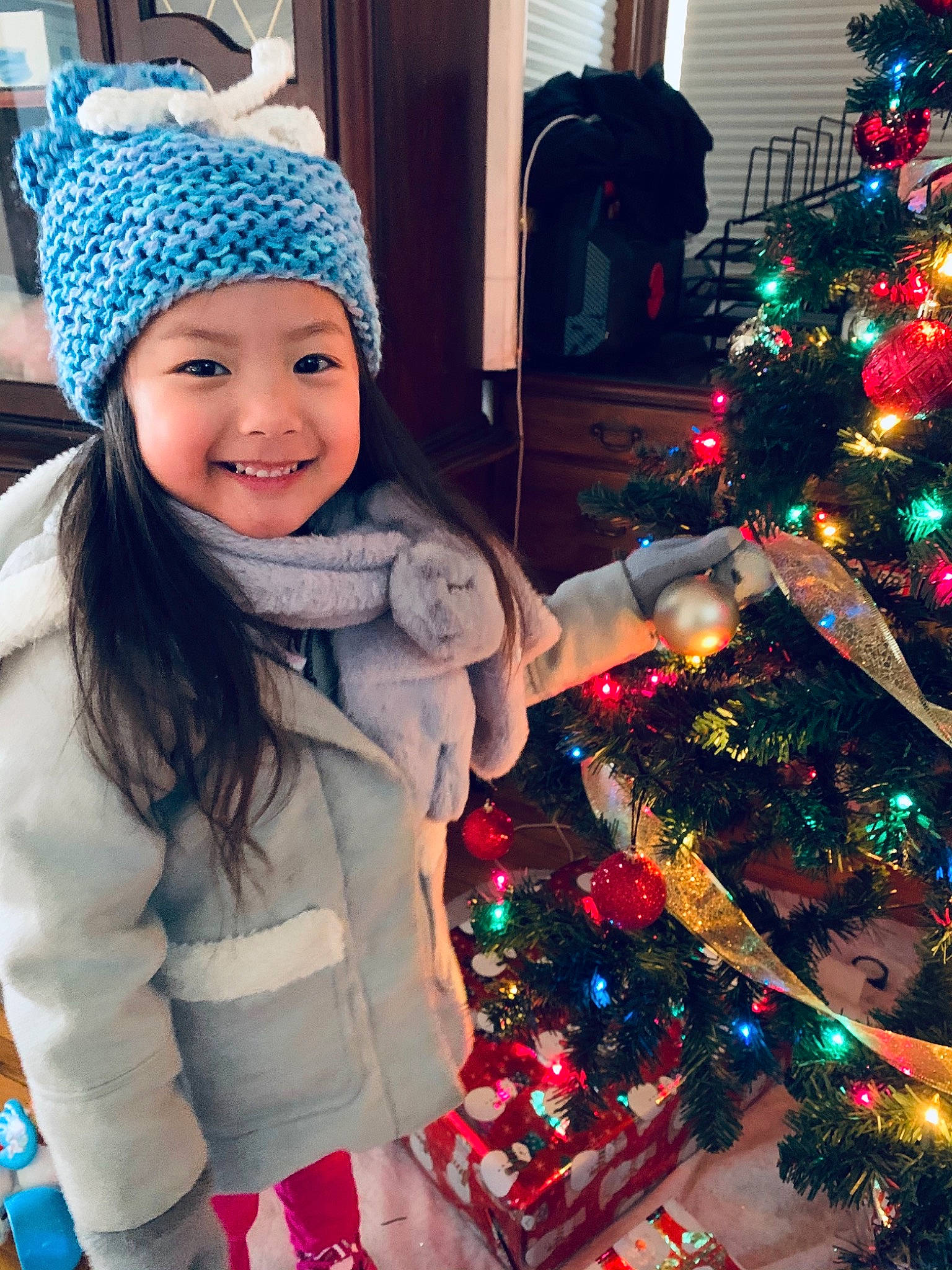 Vienna is registered to the contest to win money with this photo: beauty, blue, cap, christmas_decoration, christmas_ornament, christmas_tree, happy, head, headwear, holiday_ornament, human_body, joy, knit_cap, light, ornament, person, photograph, sleeve, smile, snapshot