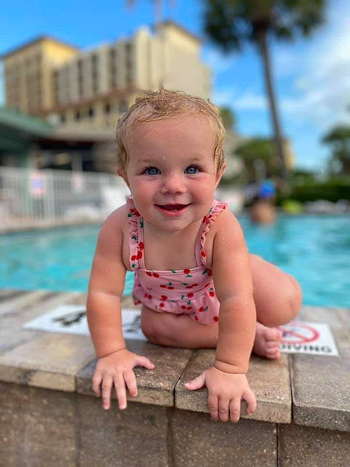 Rayna is registered to the contest to win money with this photo: azure, baby, baby_toddler_clothing, child, daytime, fun, grass, happy, human, joy, leisure, person, recreation, skin, sky, smile, standing, summer, swimming_pool, toddler