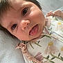 Delaney joined the competition — help win amazing prizes! baby, close_up, face, tongue, playful, infant, cute, expression, sleepwear, floral_pattern, ruffles, soft_texture, lying_down, skin, head, eyelashes, mouth, person, young_child, indoors