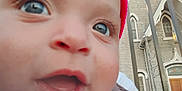Miciah is registered to the contest to win money with this photo: baby, child, close_up, face, eyes, mouth, drooling, beanie, pink_hat, skin, cheeks, eyelashes, expression, fence, bars, church, architecture, window, door, outdoor
