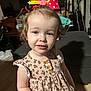 Haizel is registered to the contest to win money with this photo: toddler, child, girl, bow, hair_accessory, dress, floral_pattern, smile, indoor, furniture, guitar, curly_hair, person, cute, young_child, portrait, standing, happy, light_skin, buttoned_dress