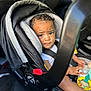 Savion joined the competition — help win amazing prizes! child, toddler, car_seat, baby, toy, bottle, car_interior, seatbelt, curly_hair, expressive_eyes, sitting, infant, safety, vehicle, young_child, casual_clothing, indoors, daylight, closeup, portrait