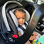 Savion is registered to the contest to win money with this photo: toddler, child, car_seat, baby, seatbelt, bottle, toy, car_interior, curly_hair, expression, hand, clothing, seat, window, headrest, person, sitting, indoors, closeup, daylight