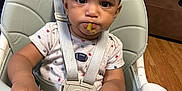 Savion joined the competition — help win amazing prizes! toddler, child, high_chair, food, green_beans, messy, expression, face, hands, tray, clothing, indoor, wood_floor, seatbelt, curly_hair, meal_time, baby_food, furniture, person, dining
