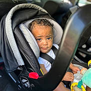 Savion joined the competition — help win amazing prizes! toddler, car_seat, child, toy, bottle, curly_hair, seatbelt, car_interior, baby, infant, window, face, expression, sitting, clothing, safety, child_protection, daylight, vehicle, cute
